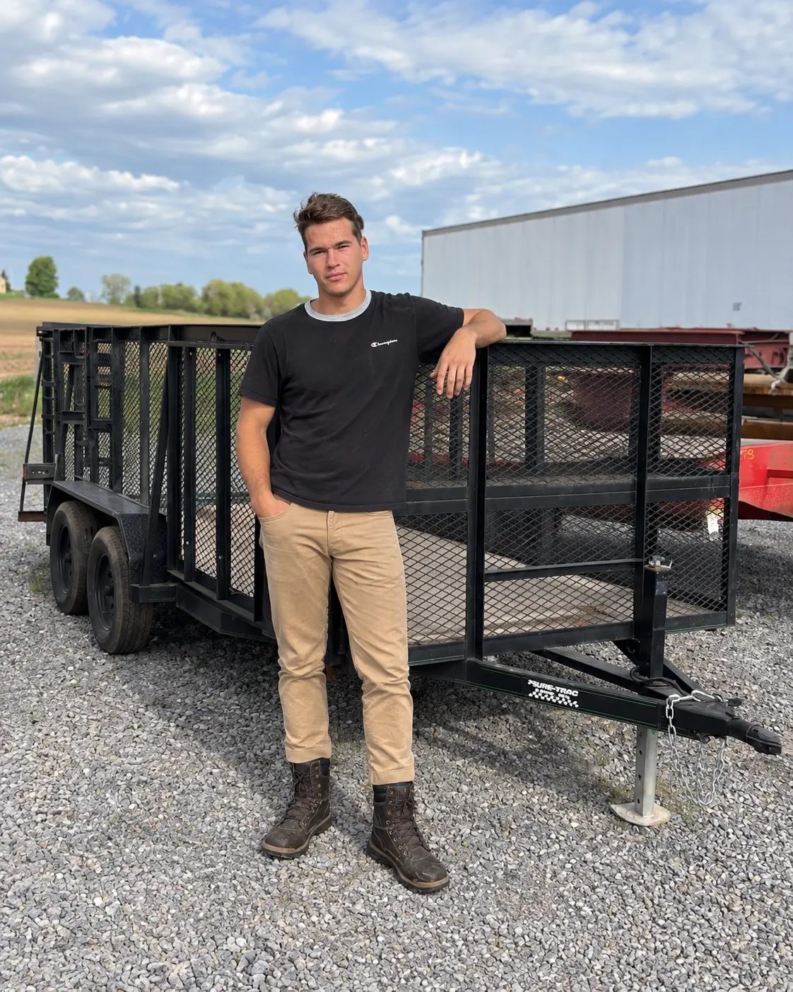 Tim, owner of Brothers Junk Removal, standing beside his utility trailer